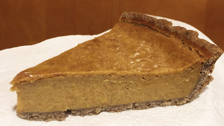 Slice of squash pie with white background