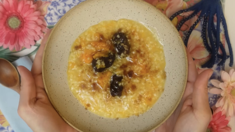 Bowl of sweet potato millet congee with floral background