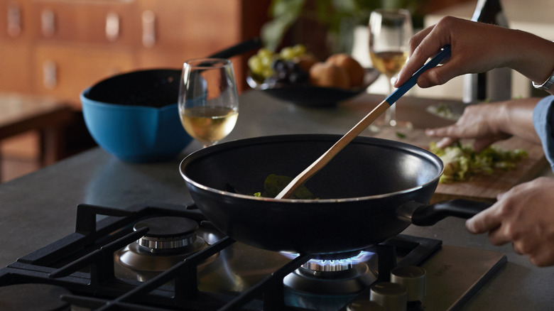 Person frying food in pan