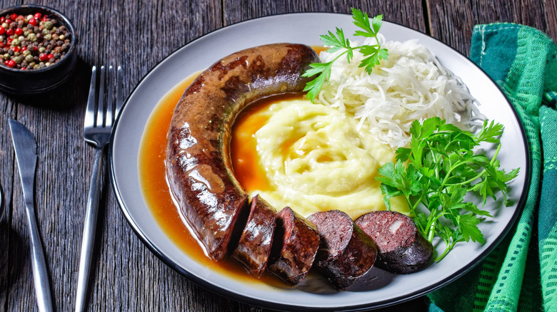 Blutwurst plated with potatoes and kraut on a wood table