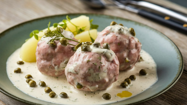 A plate of meatballs with capers and cream sauce