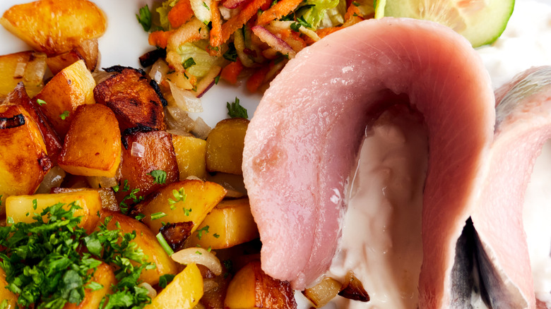 A close-up shot of a plate featuring matjesfilet served with potatoes