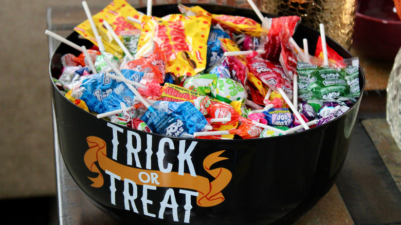 A bowl of Halloween candy with the words trick or treat written on the front