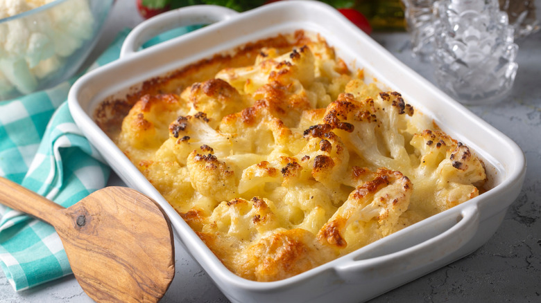 Cheesy cauliflower casserole in white baking dish