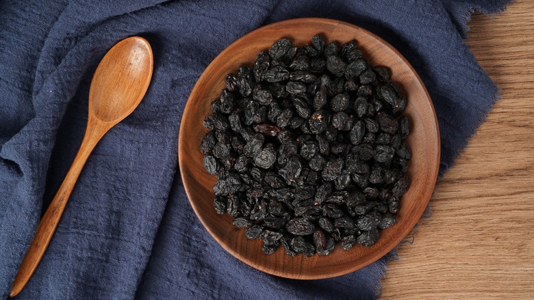 dried currants in wooden dish