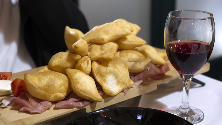 A plate of gnocco fritto and glass of wine