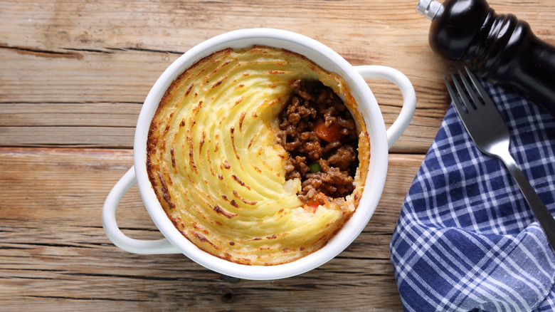 Baking dish of potato pie with a scoop taken out