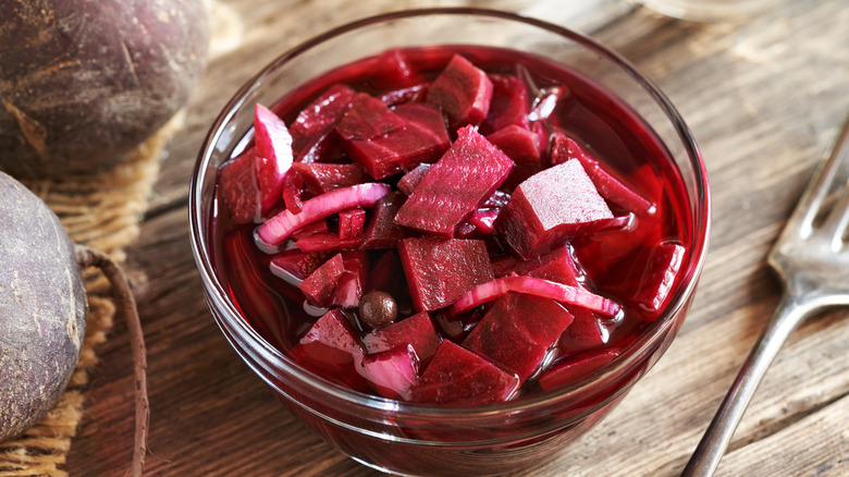 A bowl of chopped beets on a wooden table