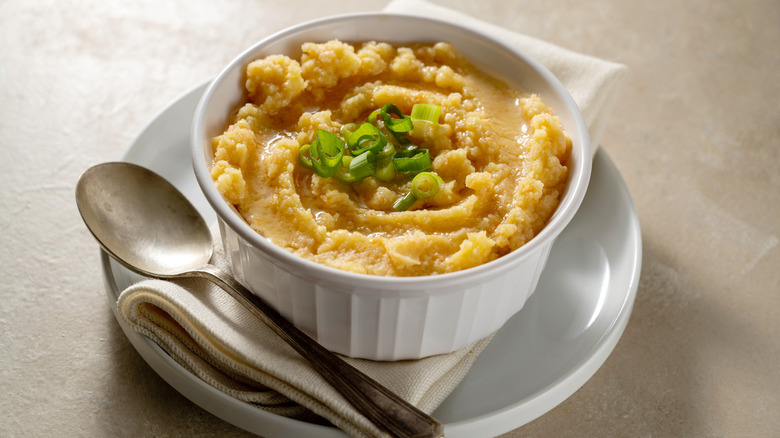 A bowl of mashed root vegetables with a spoon and napkin