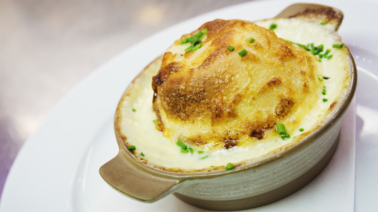 A soufflé in a miniature pot garnished with herbs