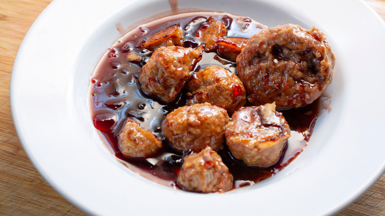 White bowl of grape jelly meatballs