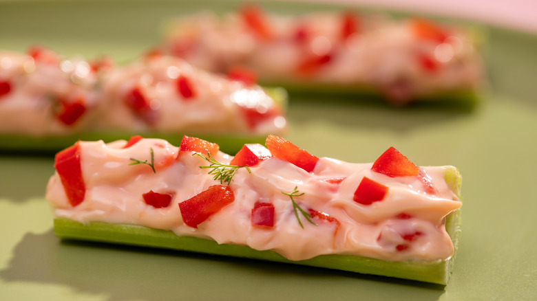 Stalks of stuffed celery on green background
