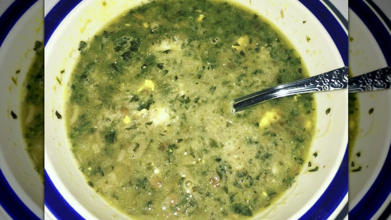 Overhead view of green dandelion soup with spoon
