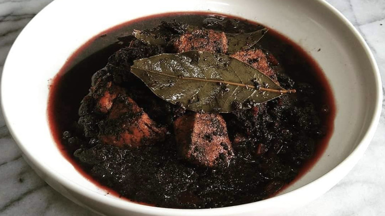 Bowl of blood soup with meat and bay leaf
