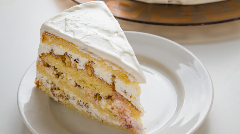Slice of white tiered cake on plate