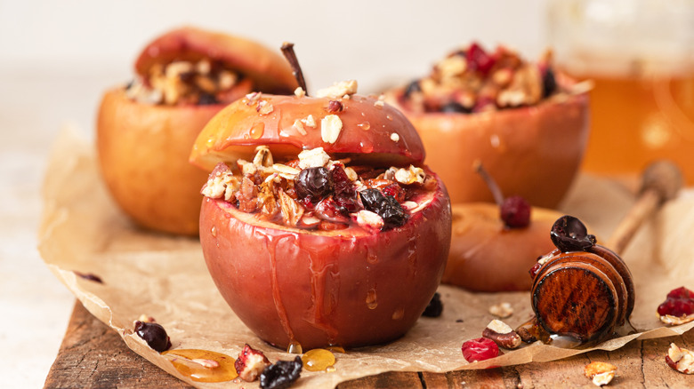 Three baked apples with fruit and nut filling and honey drizzle