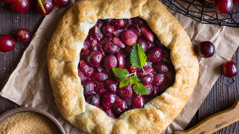 Grape pie with rustic background and bunches of grapes