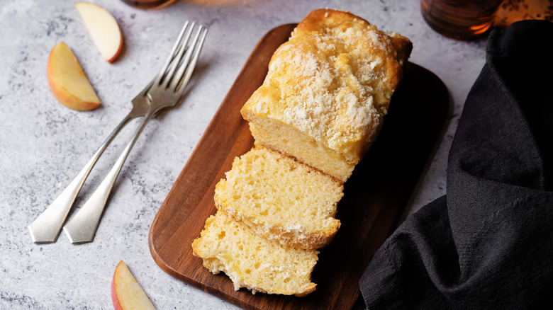 Sponge cake with two slices cut and forks with apple slices