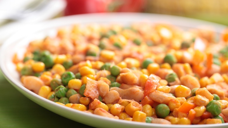 Close-up view of succotash made with corn, beans, and vegetables.