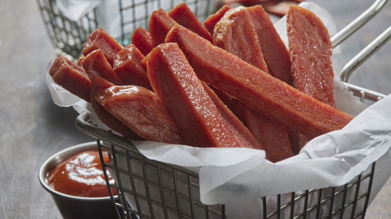 Fried spam fries in a basket with ketchup