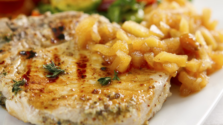 Close-up of a pork chop served with applesauce