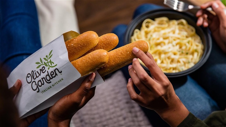 Hand takes Olive Garden breadsticks