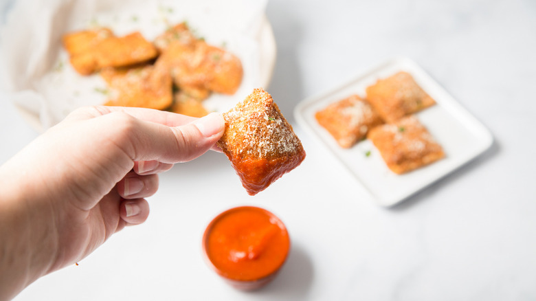 hand holding dipped toasted ravioli