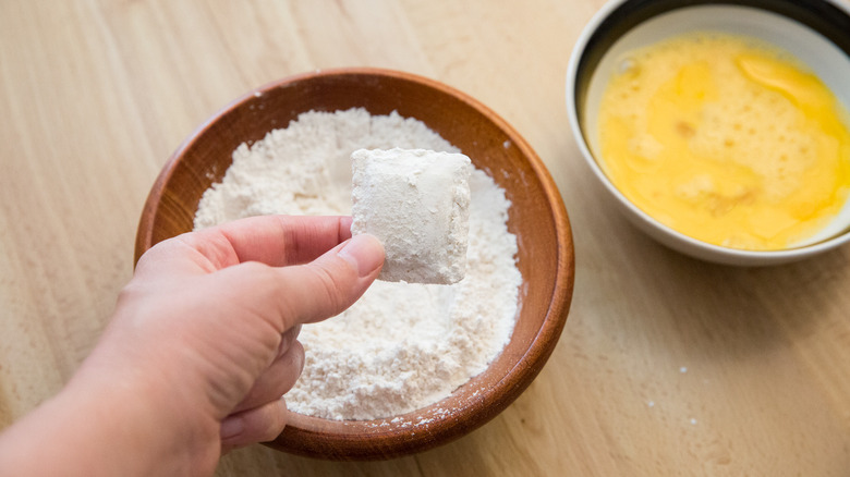 hand holding flour-coated ravioli