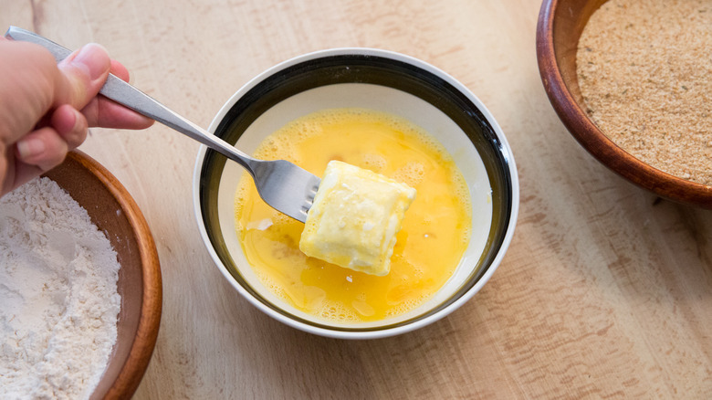 Fork lifting egg-covered ravioli