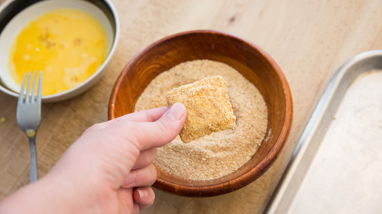 Hand holding breadcrumb-covered ravioli