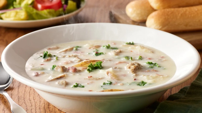 A bowl of Zuppa Toscana with breadsticks