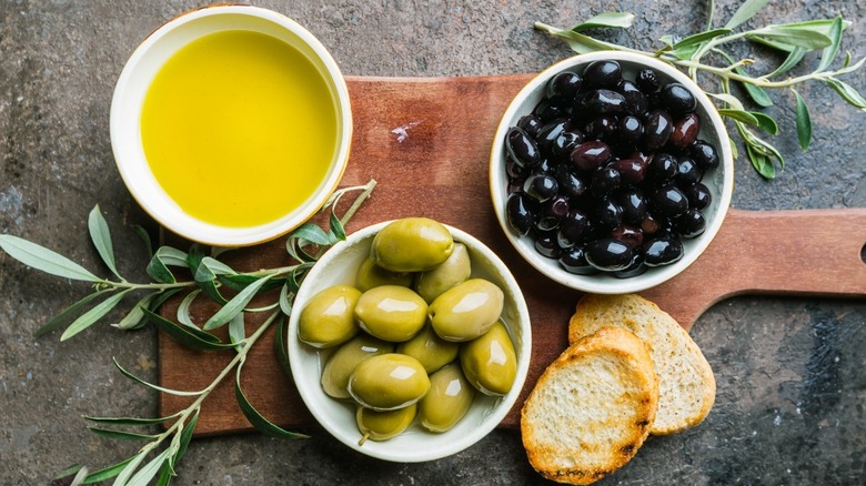 Olive oil and olives on brown wood