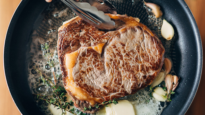 Cooking ribeye steak in a pan