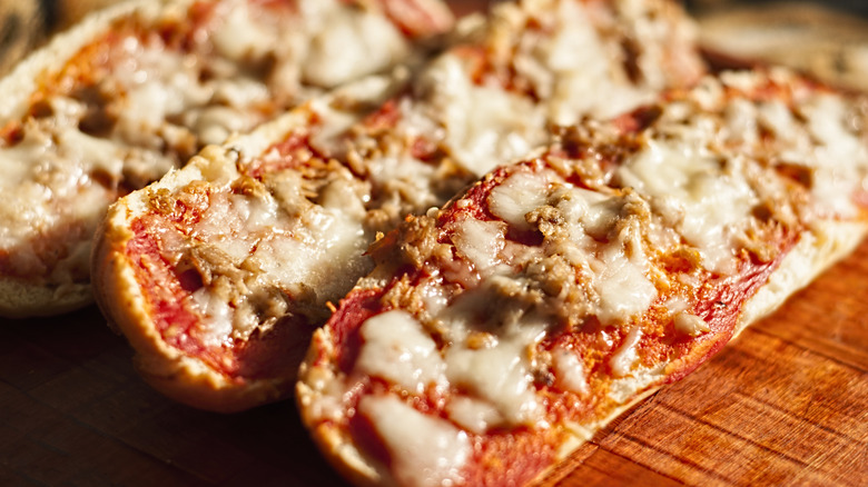 close up of French bread pizza on wood butcher block