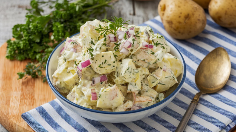 Bowl of potato salad with red onions and dill