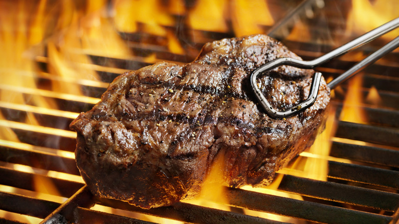 Steak over fire on the grill close-up