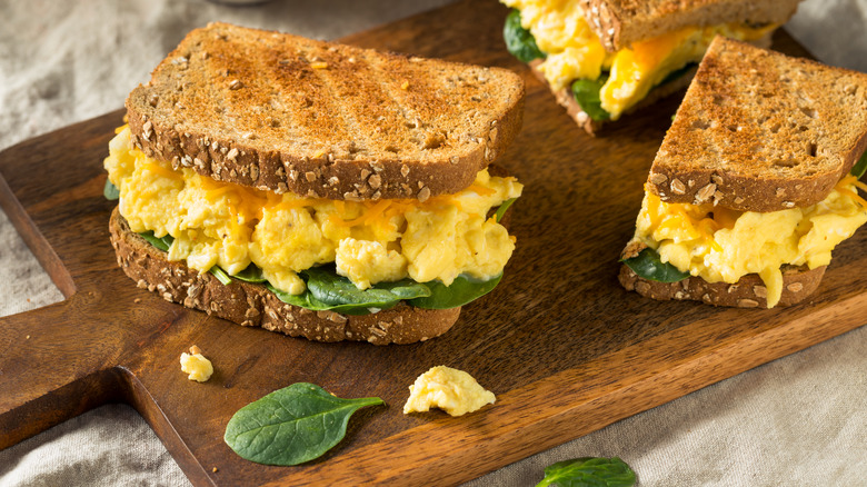 A simple scrambled egg sandwich on a cutting board