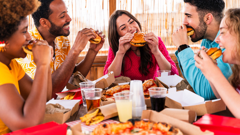 Group of friends eating burgers