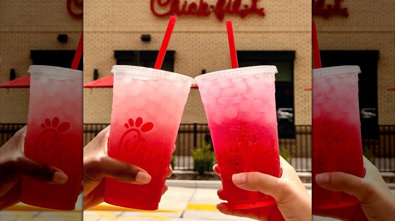 Two people holding pineapple dragonfruit Sprite beverages in front of Chick-fil-A.