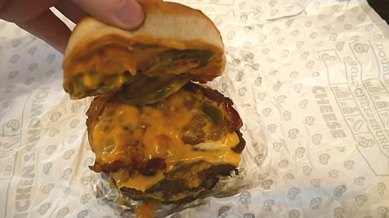 The A&W Jalapeño Queso Bacon Double Cheeseburger next to fries and a drink