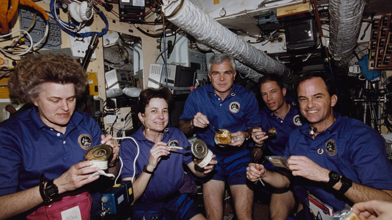 astronauts eating in space station