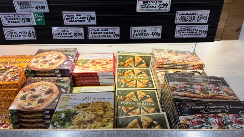 Assorted frozen pizzas in Trader Joe's freezer section.