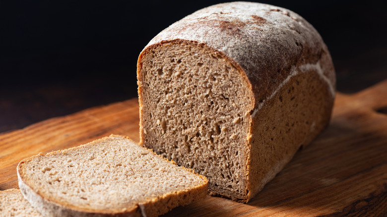 Loaf of sliced rye bread on a wood cutting board