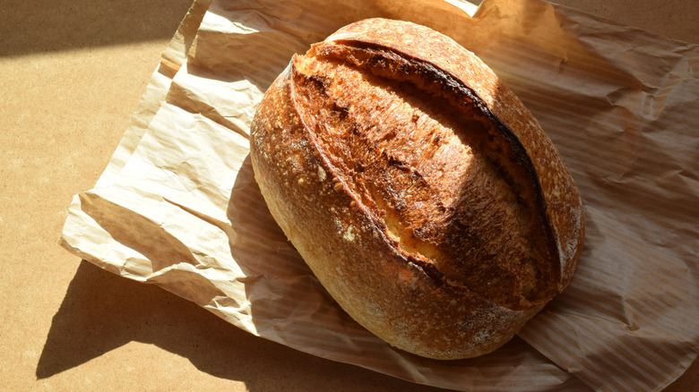 Artisinal sourdough loaf on top of brown paper