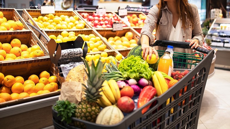woman putting fruit in shopping cart