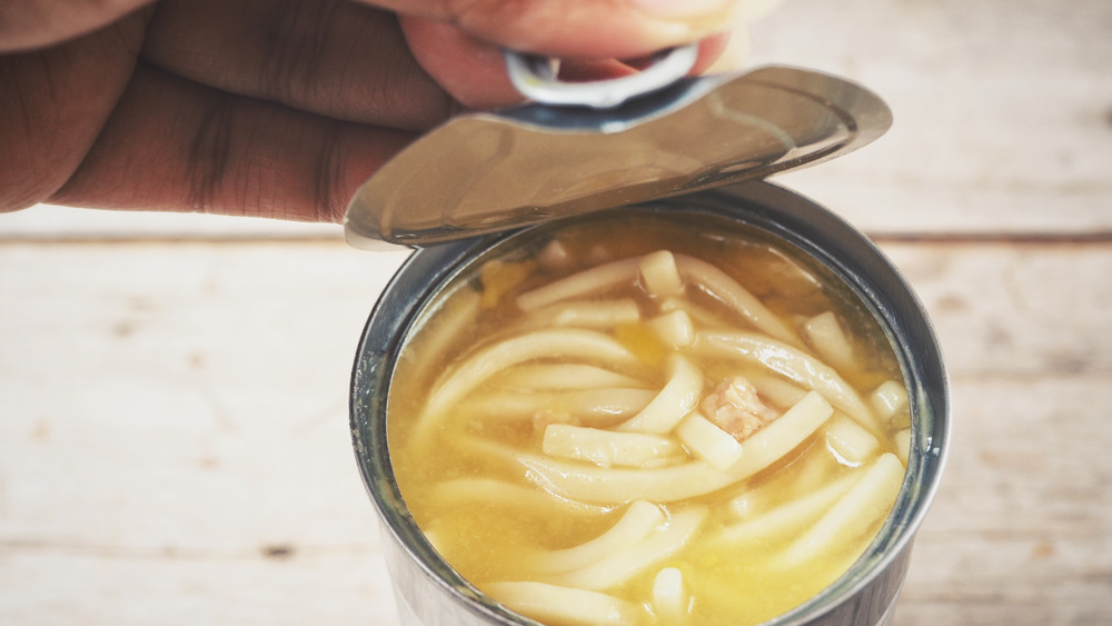 Hand opening can of soup