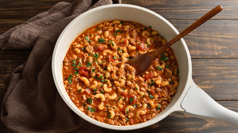 Pasta simmering in tomato sauce in pan