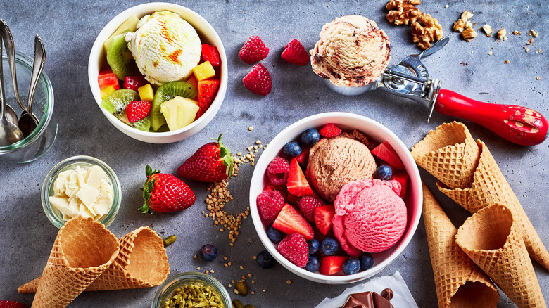 ice cream spread with bowls, fresh fruit and cones