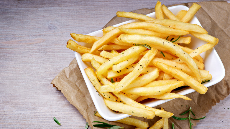 Seasoned French fries on wood table