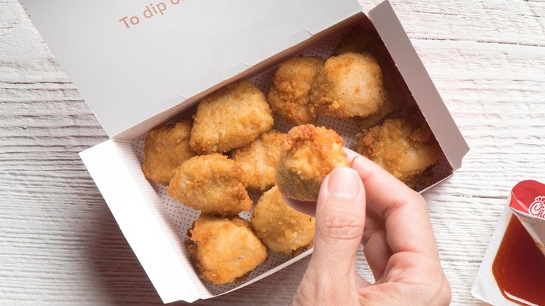 Hand holding Chick-fil-A nuggets